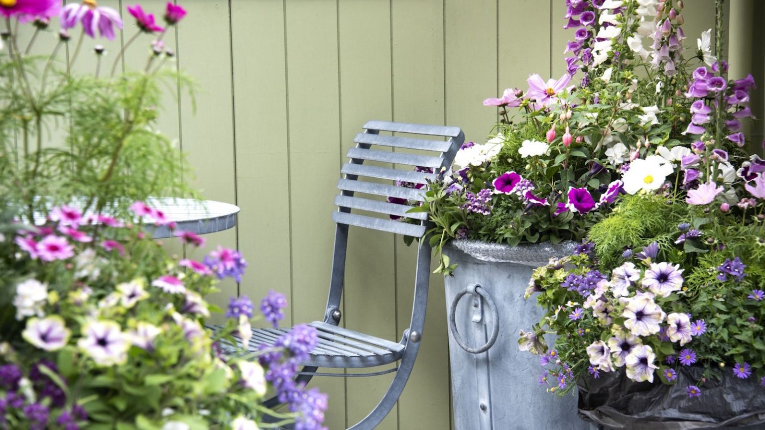 Le support pour plantes 2 en 1 d’IKEA fait également office de plate-bande de jardin surélevée – et change la donne pour les petits patios et balcons Garden seat surrounded by container plants, green backdrop