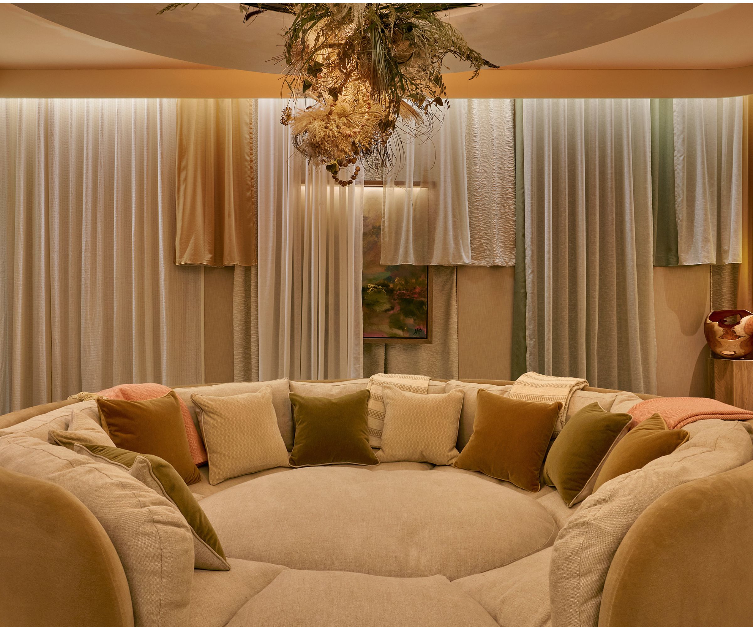 le 'noyau' chambre à WOW!House 2026 comprenant un canapé géant de style lit pour chien avec des murs drapés et une installation au plafond