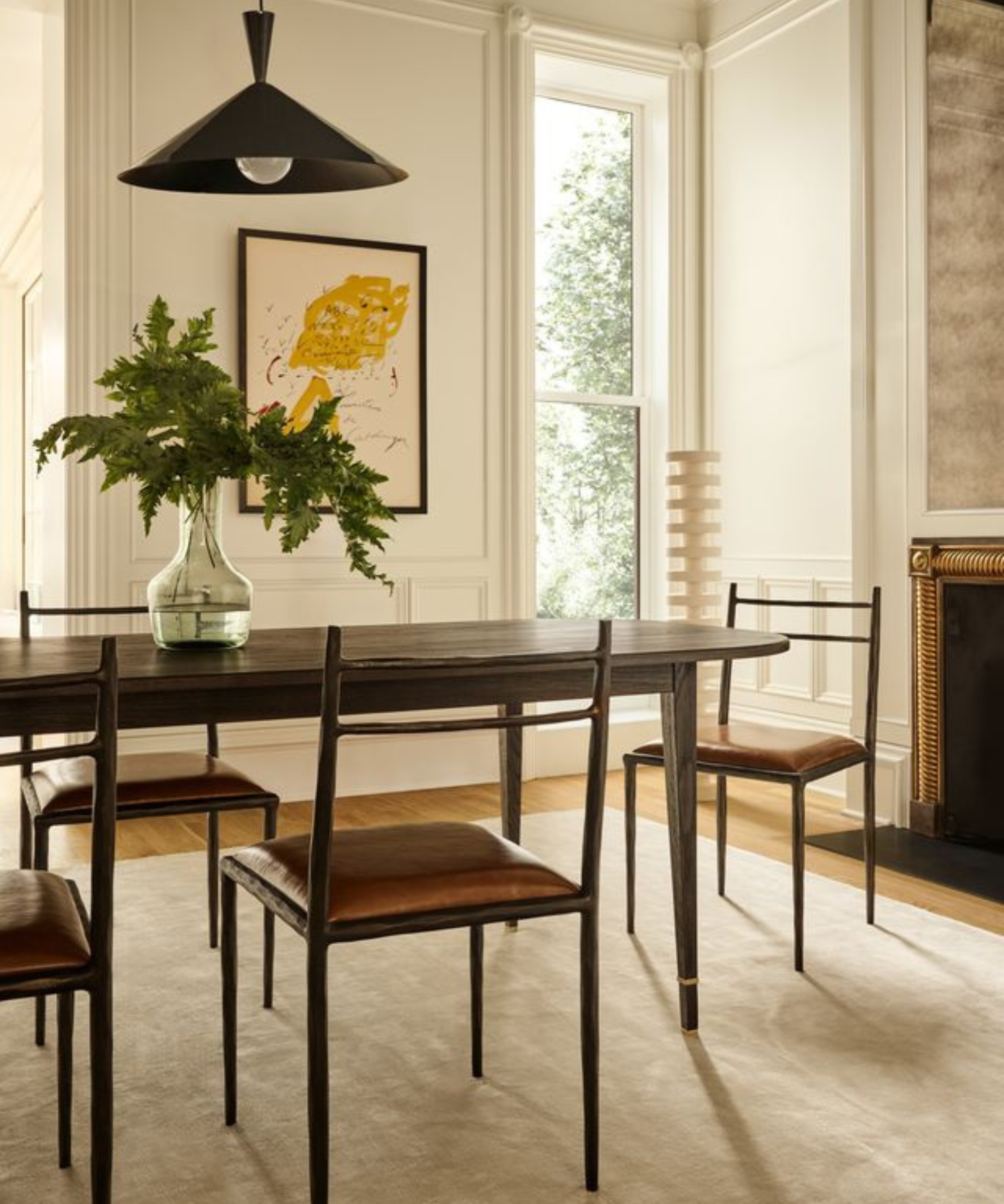 une salle à manger avec une table en bois sombre, plusieurs chaises et un tapis beige clair