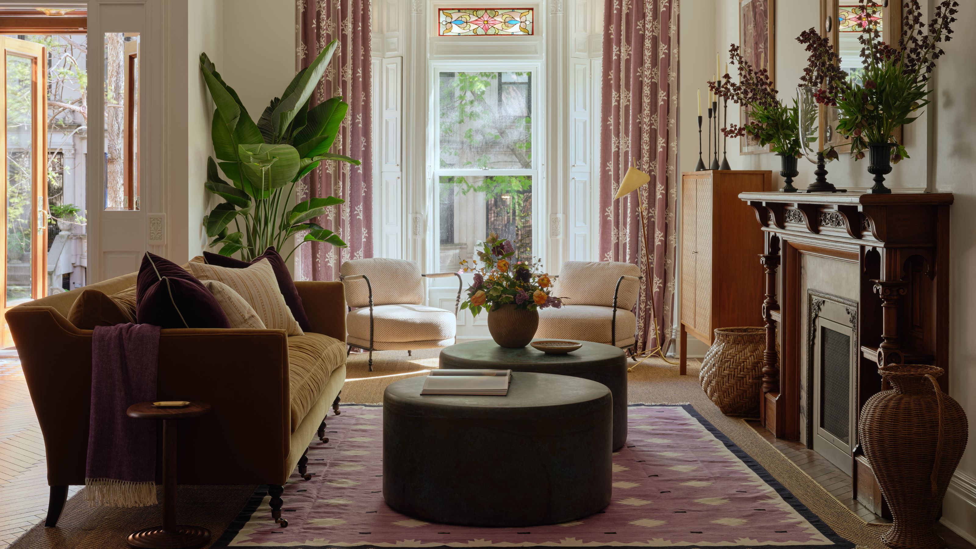 le salon d'une maison de ville de Park Slope à New York avec une immense baie vitrée avec des vitraux, une cheminée en bois ancienne et un mobilier moderne