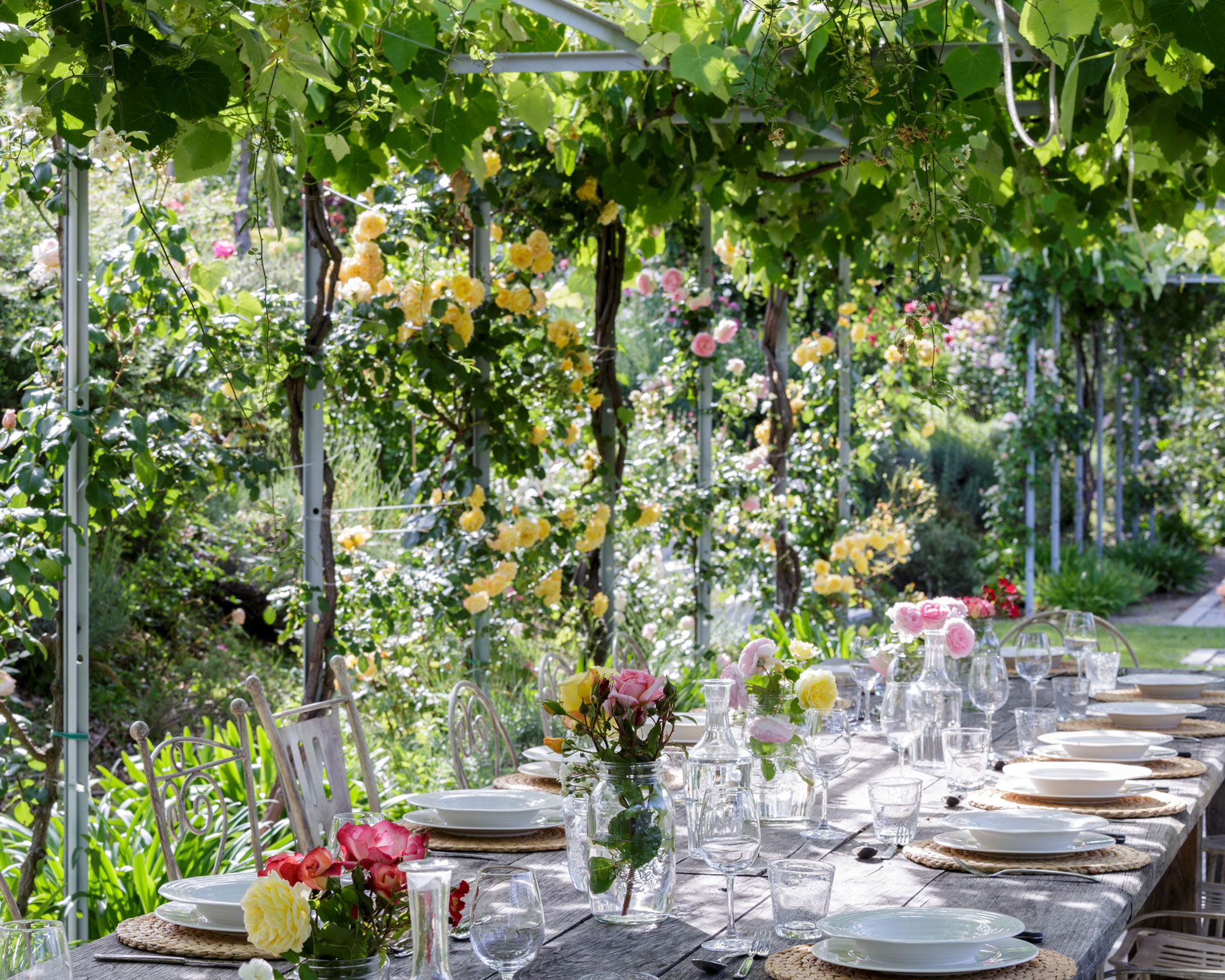 table à manger en plein air avec fleurs, lin et porcelaine