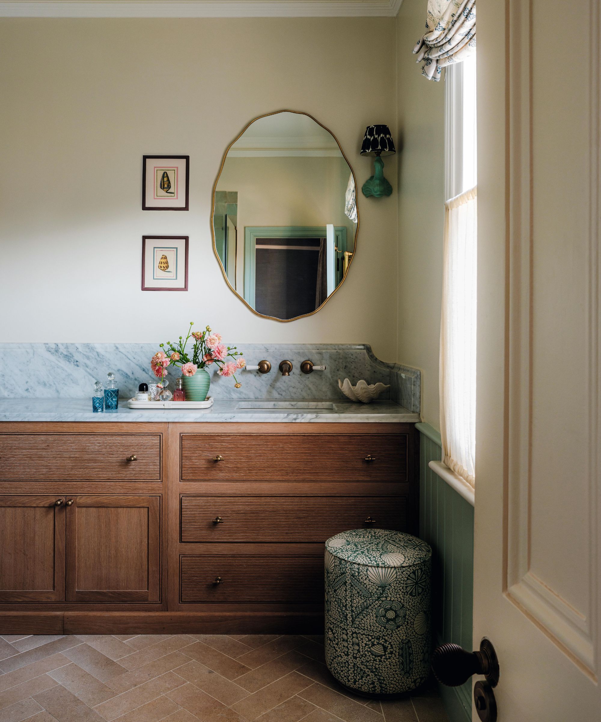 une salle de bain douce et neutre avec une vasque chaleureuse en bois et du marbre veiné bleu