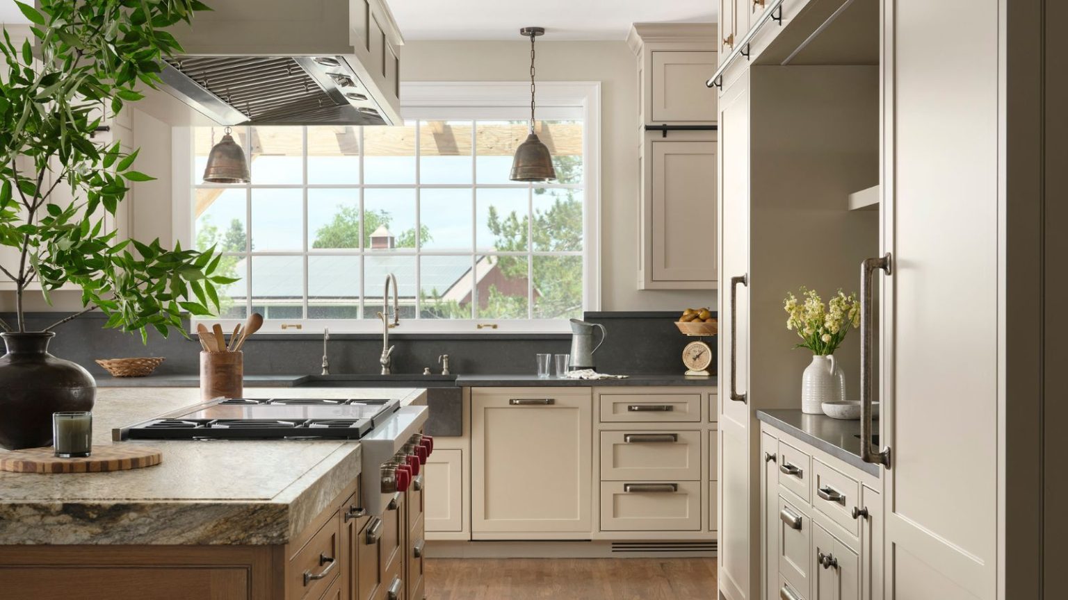7 couleurs et matériaux de comptoir de cuisine qui se démoderont en 2026 – et par quoi les remplacer A neutral kitchen with black countertops and a marble countertop on the island