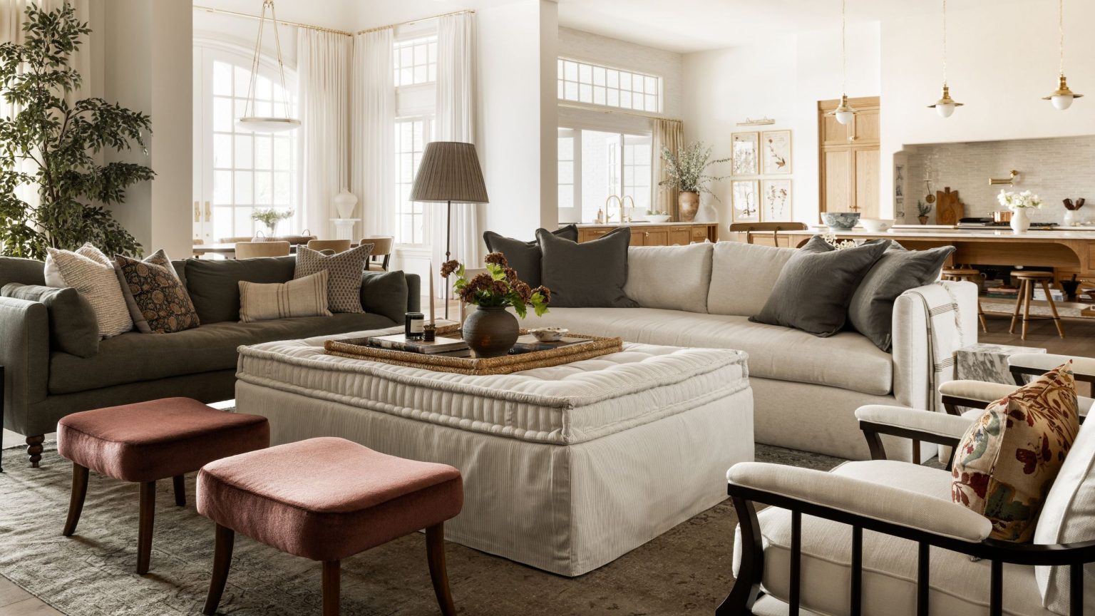 Le style « East Coast Bones, Desert Soul » de Shea McGee est la formule de décoration que je copierai cette année – Achetez 24 pièces pour y arriver a large open plan living room kitchen area with large neutral couch, linen ottoman, rust red stools and dark green grey accents