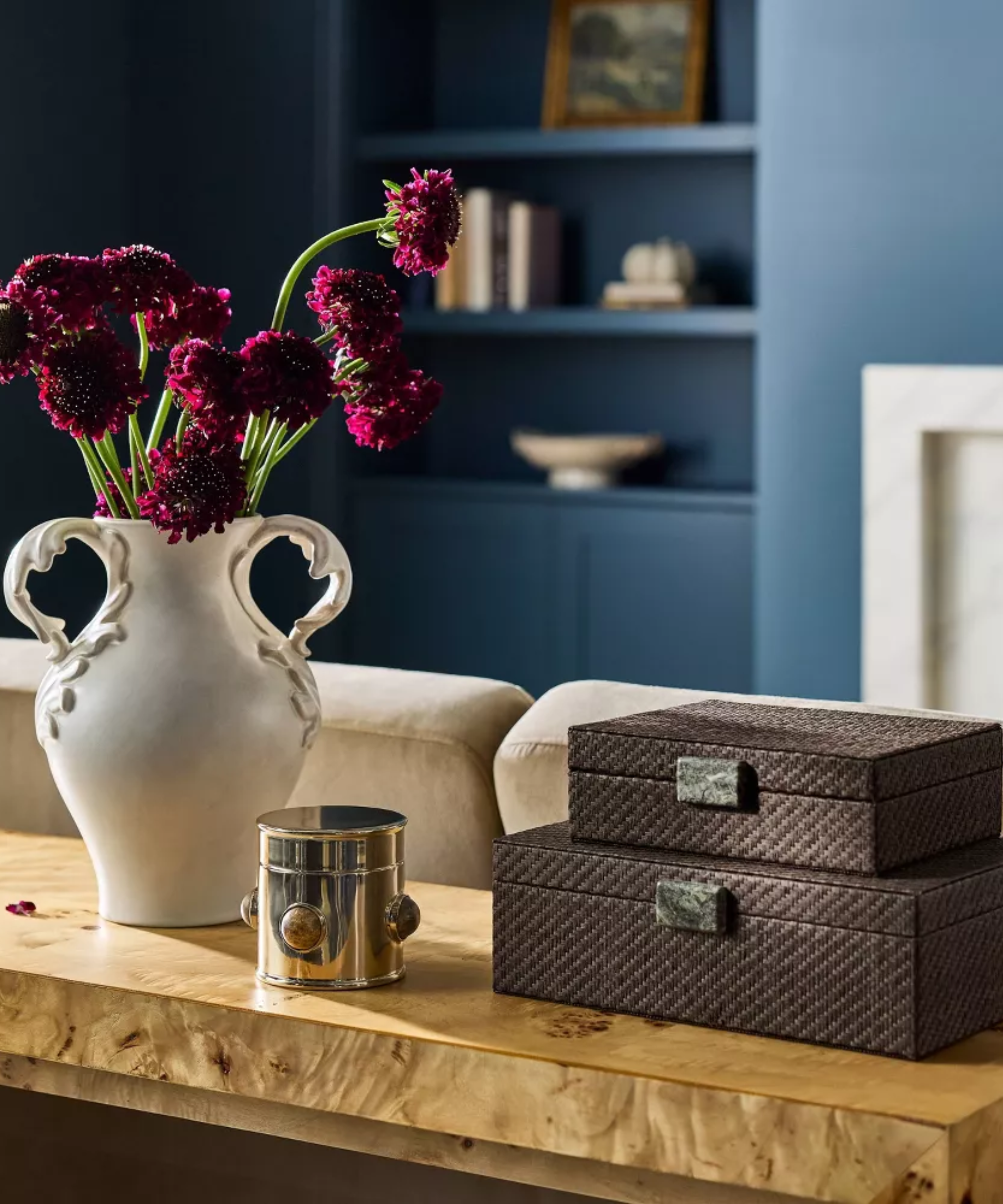 une scène de table avec des boîtes, une boîte et un vase avec des fleurs