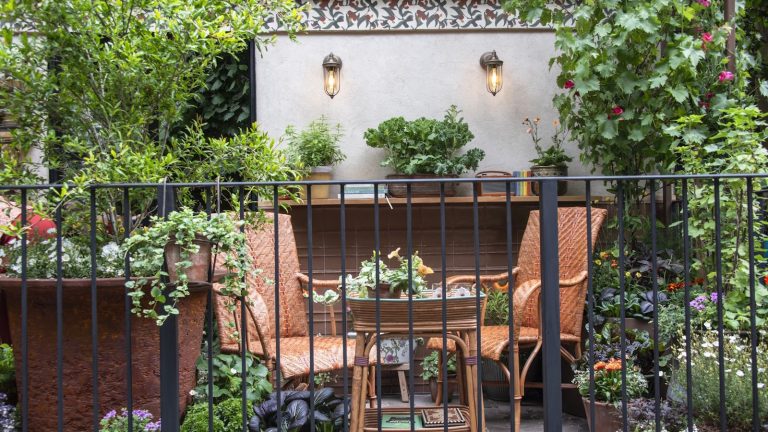 Cet astucieux ensemble de jardinières IKEA transforme un petit balcon en un potager productif – il est même parfait pour les fraises Two chairs and a table surrounded by shrubs and flowers in pots on a balcony at the RHS Chelsea Flower Show