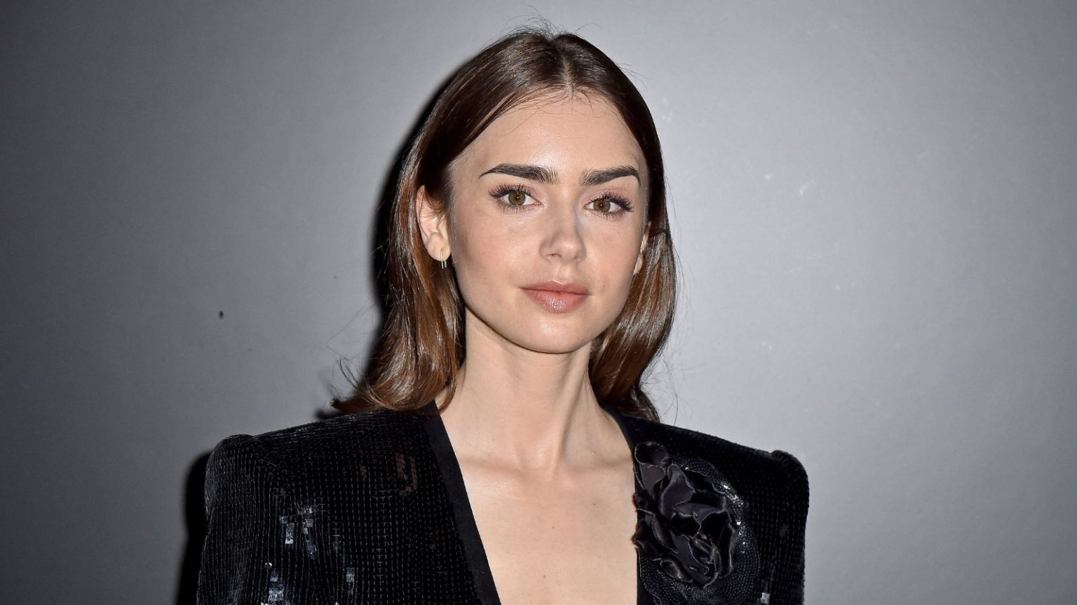 La lampe de salle de bain géométrique de Lily Collins est le complément inattendu (mais ultra-chic) de son espace minimaliste scandinave lily collins on a gray background
