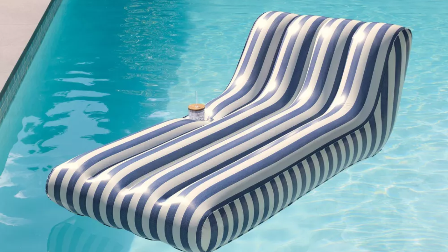 Je n’aurais jamais pensé qualifier un flotteur de piscine de « chic » – mais ensuite j’ai vu celui-ci de la nouvelle collection Target de Joanna Gaines a striped blue and white pool float in a pool