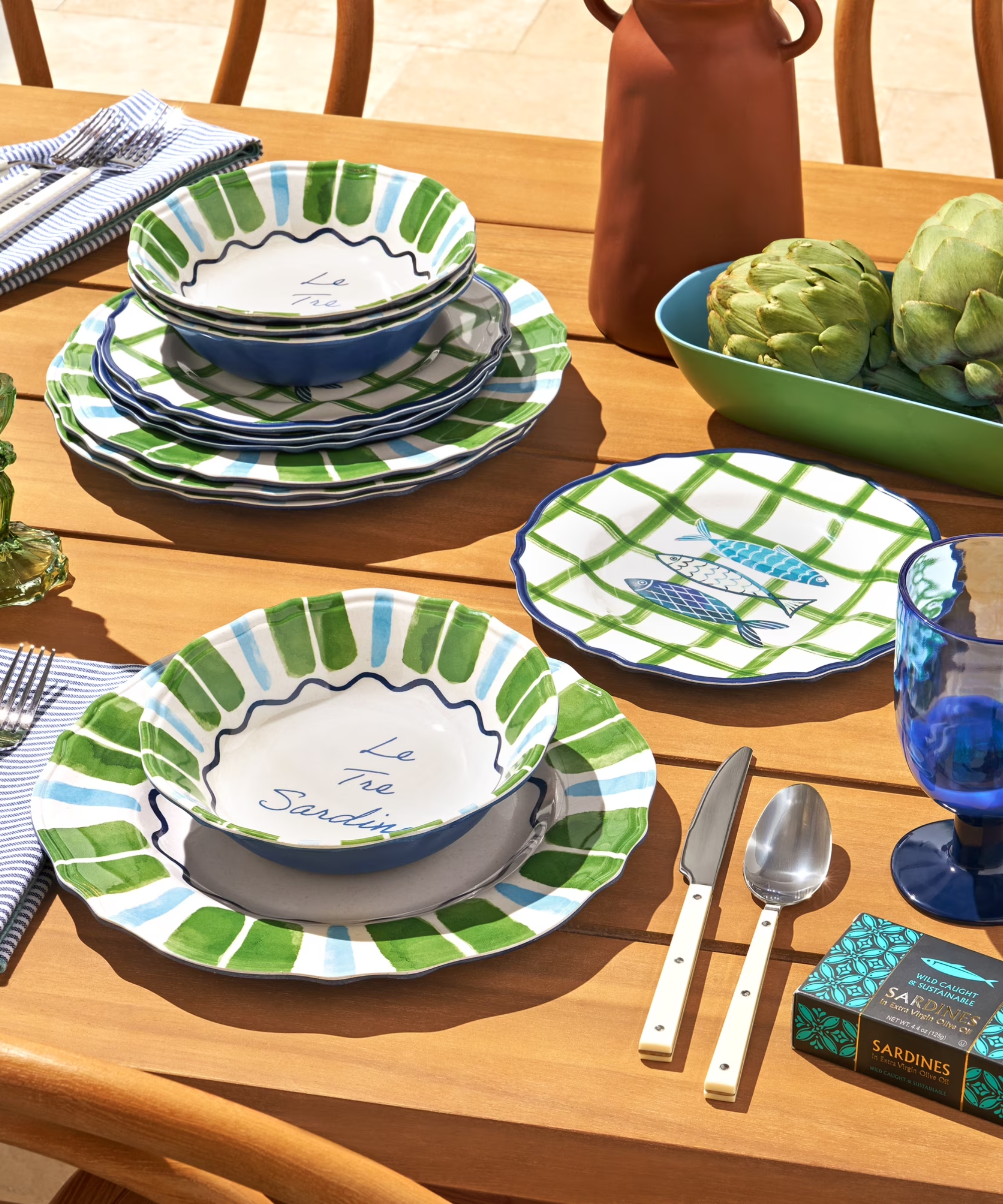 un service de vaisselle vert, blanc et bleu avec des motifs de sardines dessus