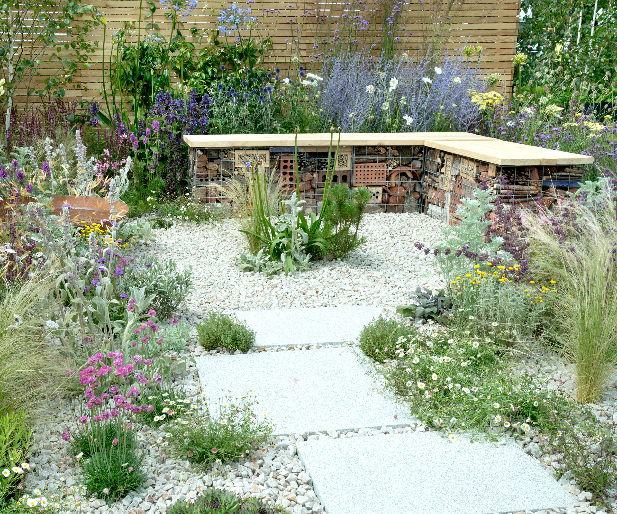 terrasse en gravier avec banc de jardin animalier et plantation naturelle