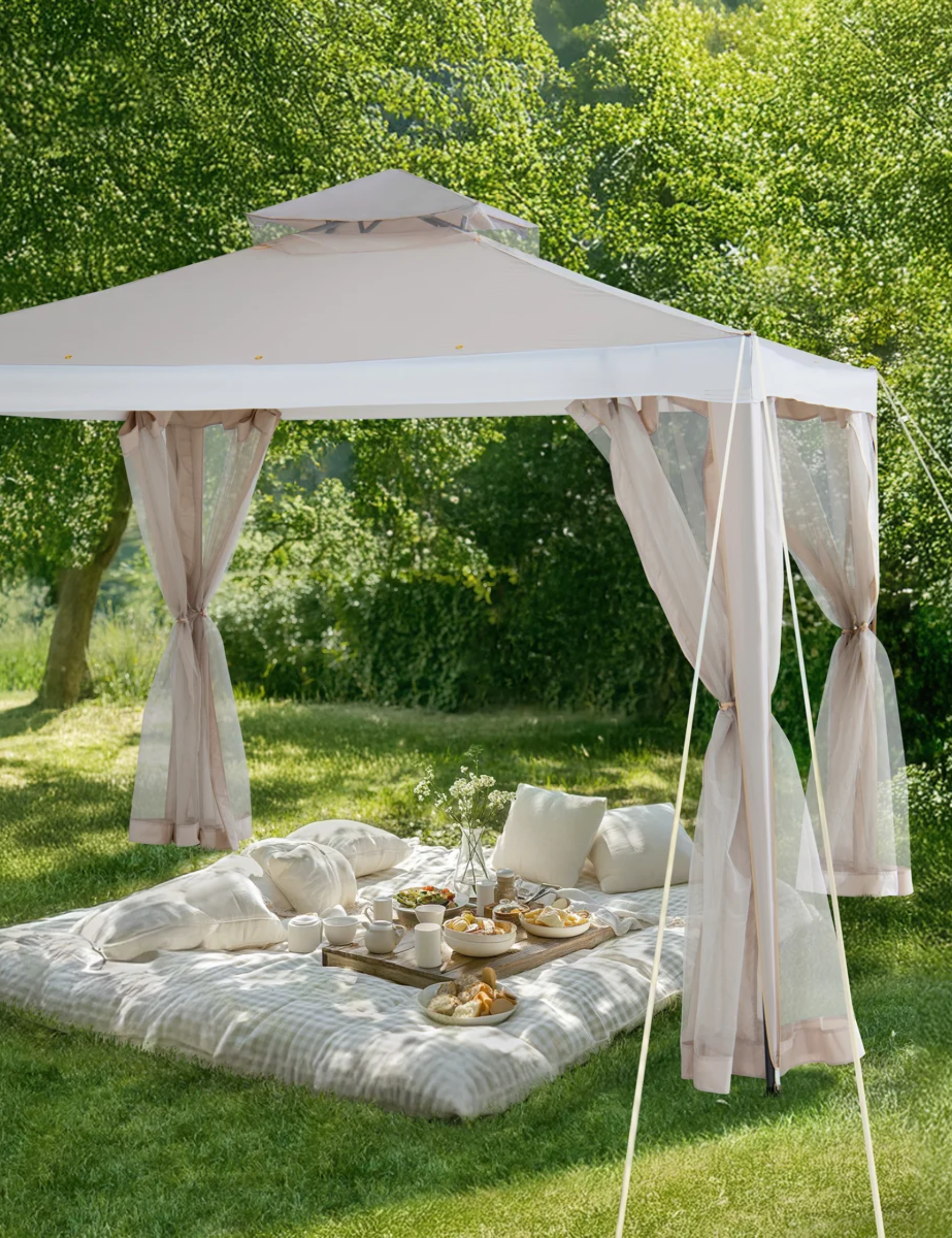 Gazebo beige à toit souple avec filet surplombant une charmante scène de pique-nique sur une pelouse herbeuse entourée d'arbres