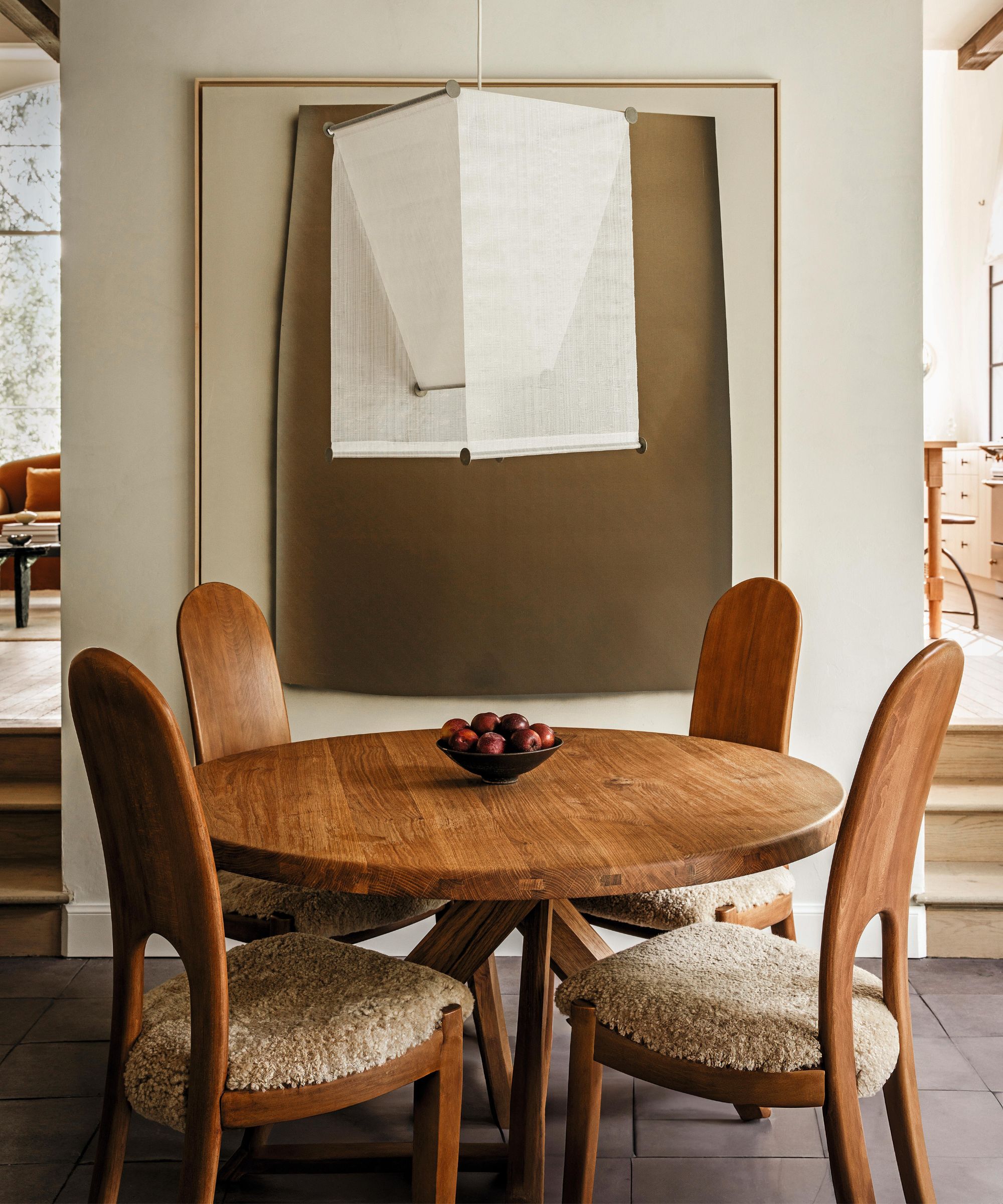 un petit coin petit-déjeuner de style vintage neutre avec un art abstrait et une suspension au plafond en lin