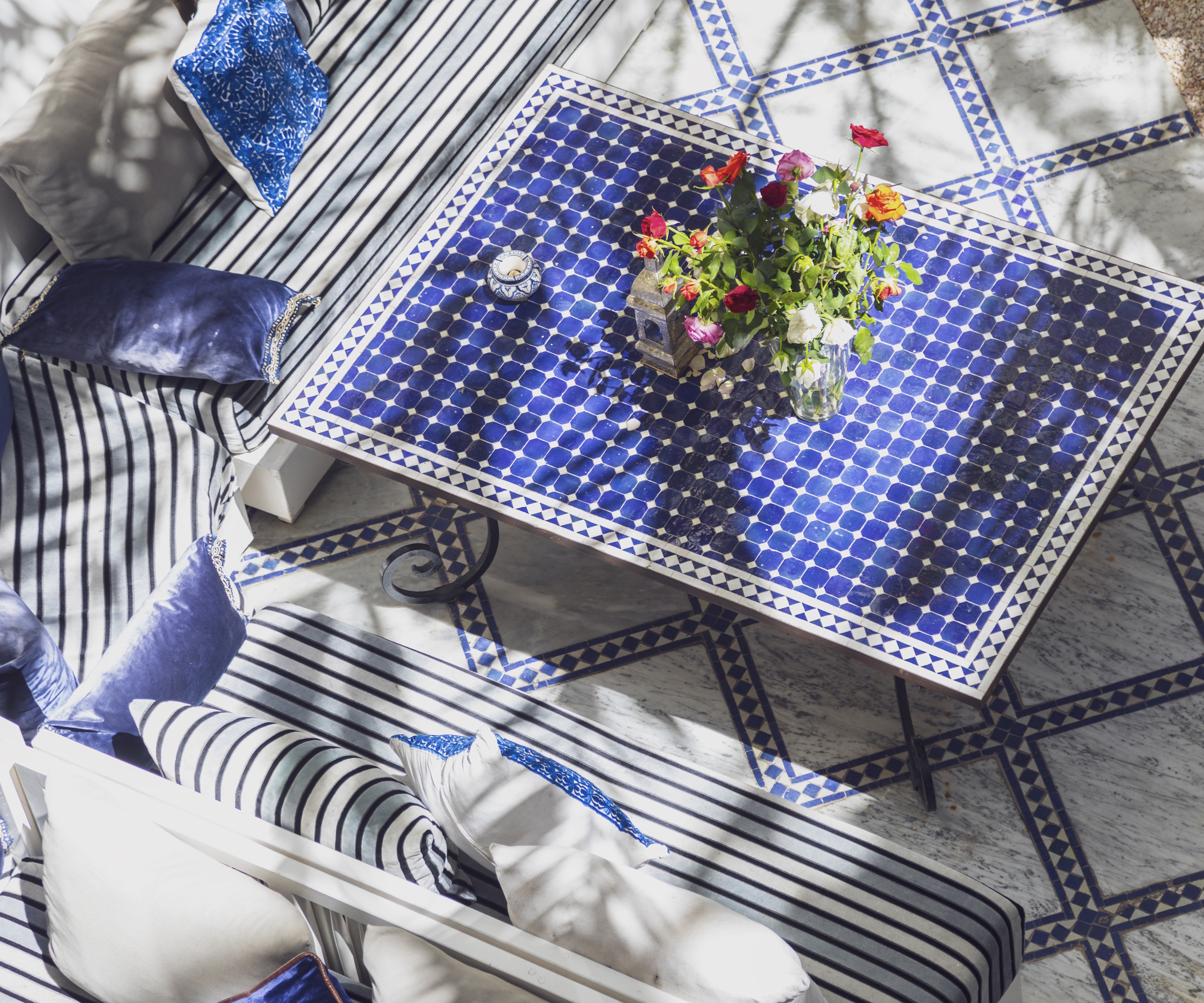 Cour marocaine, table avec carreaux bleus et canapés rembourrés