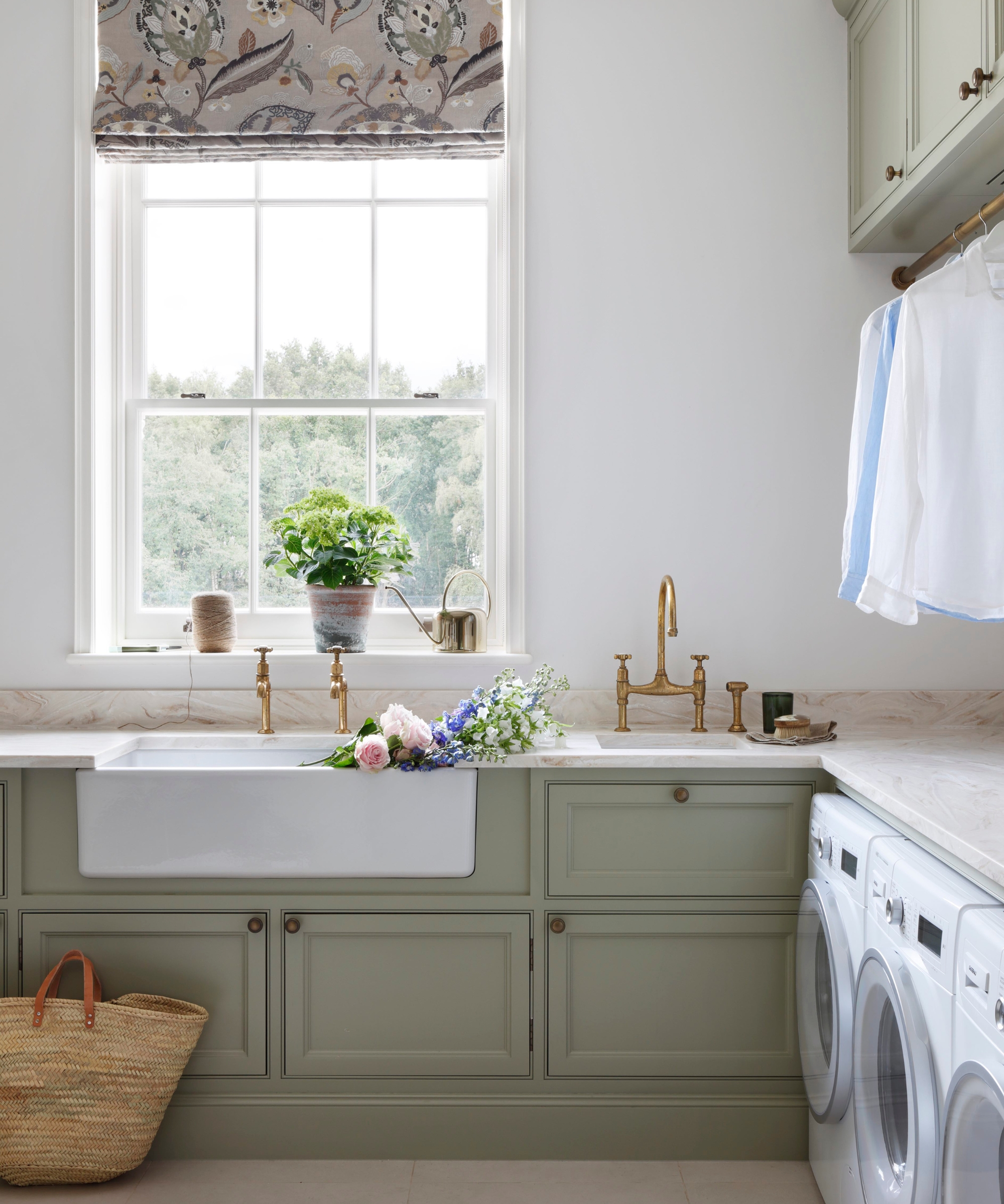 Une buanderie aux murs blancs et au décor Farrow &amp; Ball's French Grey pour les armoires