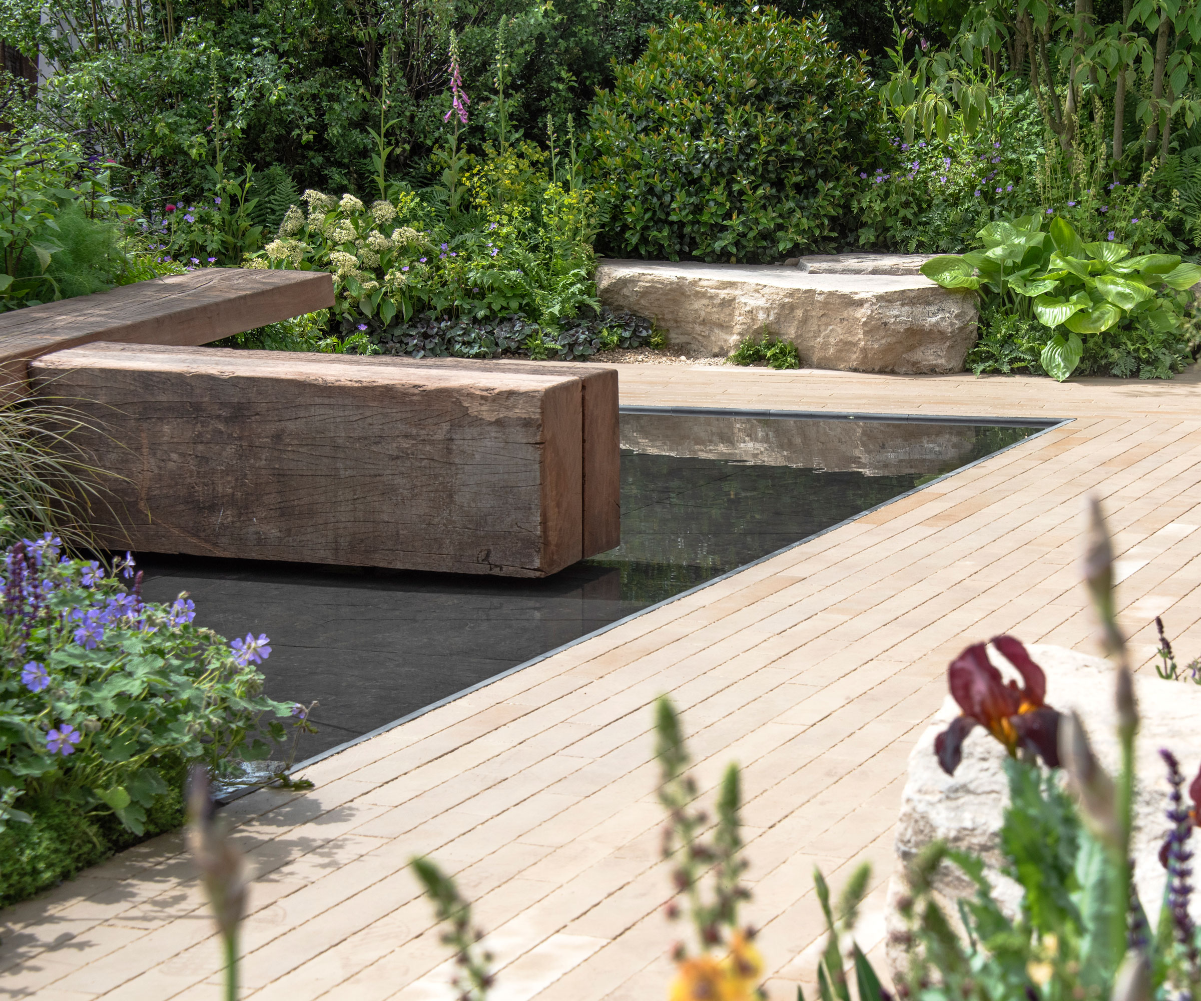 aménagement paysager moderne avec planches de terrasse et jeu d'eau, aménagement paysager de roches et plantation