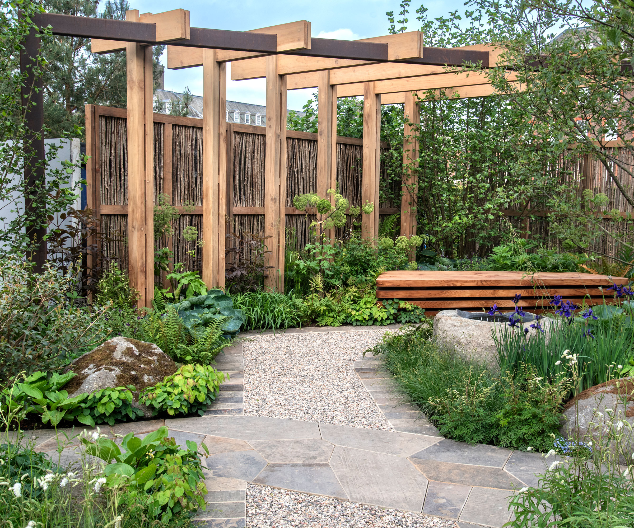 conception de jardin moderne avec grande pergola en bois, banc de jardin, plantation et aménagement paysager avec roches et gravier