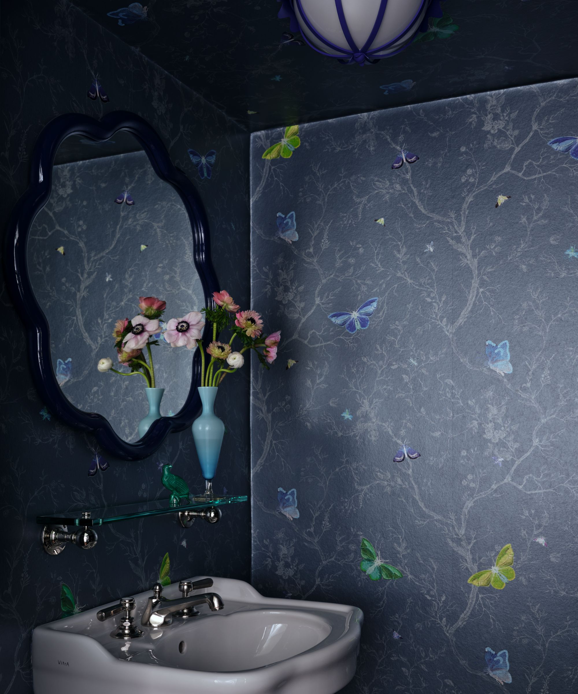 Une petite salle d'eau avec du papier peint à motif papillon bleu marine foncé sur les murs et le plafond, un petit lavabo avec des ferrures chromées et un miroir festonné au mur.