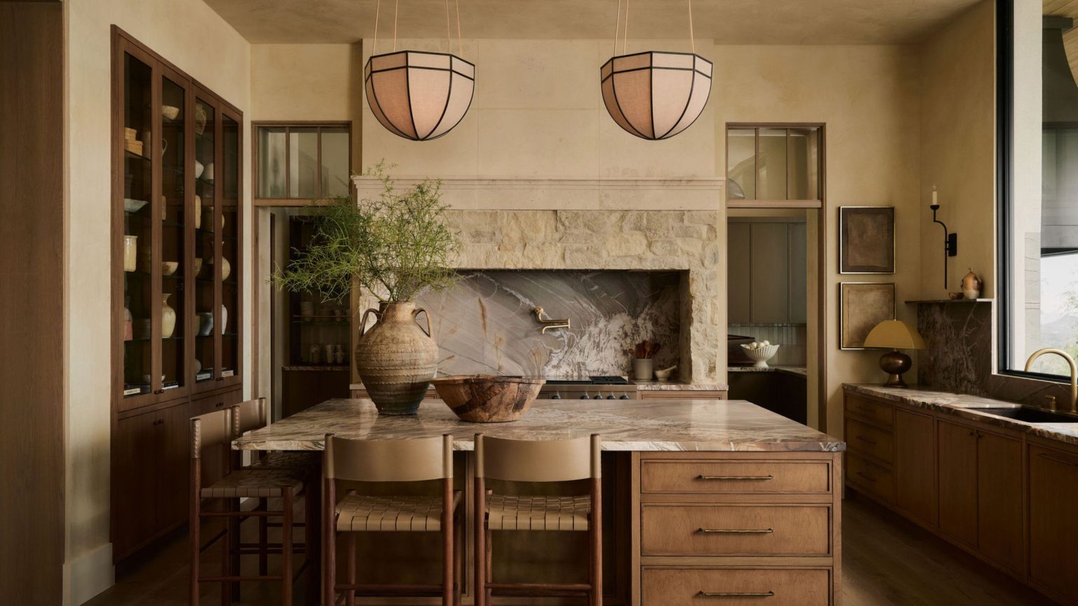 Cette cuisine neutre et chaleureuse prouve que les designs les plus frappants n’ont pas besoin de couleurs vives A warm neutral kitchen with bold stone countertops and a wooden island