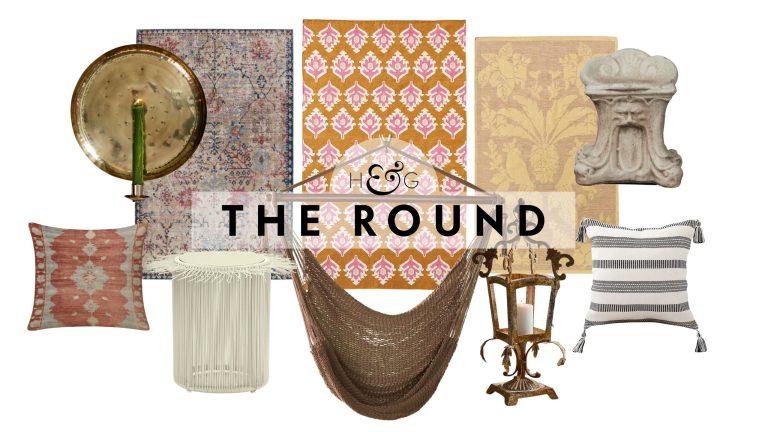 Boho outdoor decor, including patterned throw pillows, a raffia side table, brass candle sconce, outdoor rugs, woven hammock chair, lantern, and cast cement stool, pictured against a white background